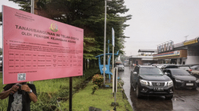 Pekerja memasang plang penyitaan di rest area km 21 B Jalan Tol Jagorawi, Gunung Putri, Bogor, Jawa Barat, Rabu (21/5/2025). (Ist)